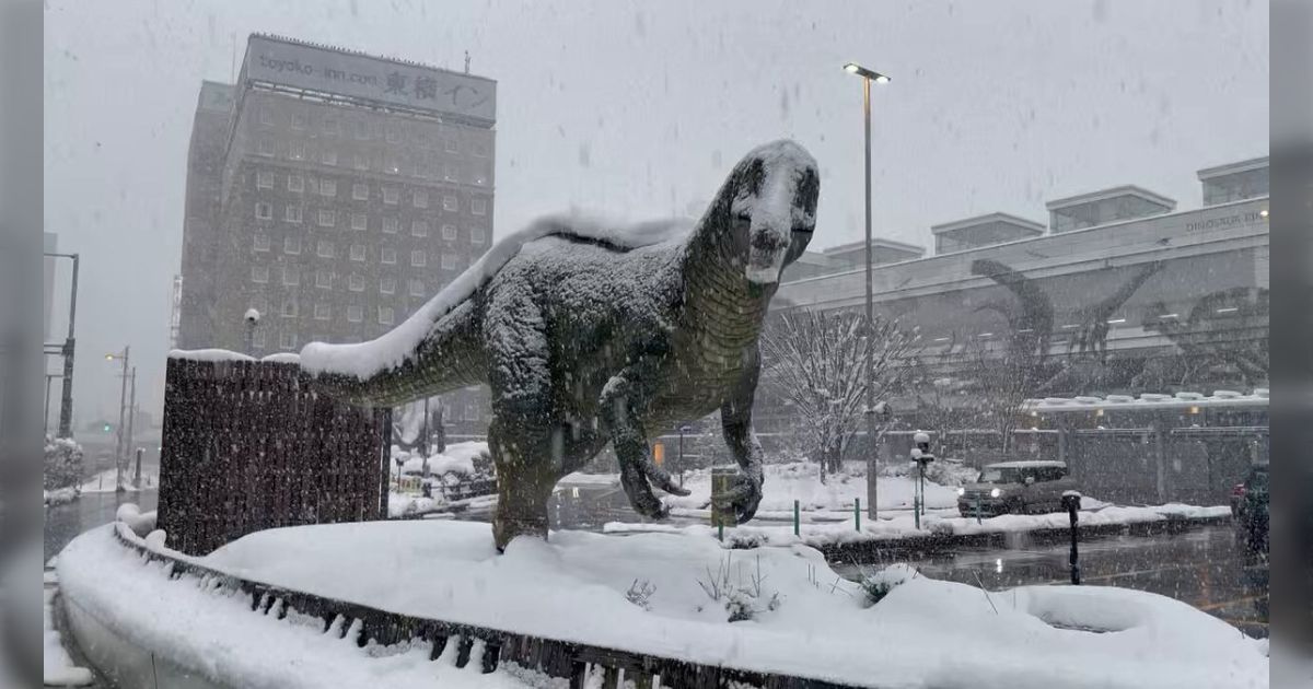 恐竜絶滅のイメージが湧いてくる 福井駅の前に置かれた恐竜のロボット、大雪で雪を被ってまるで絶滅時のような姿になる